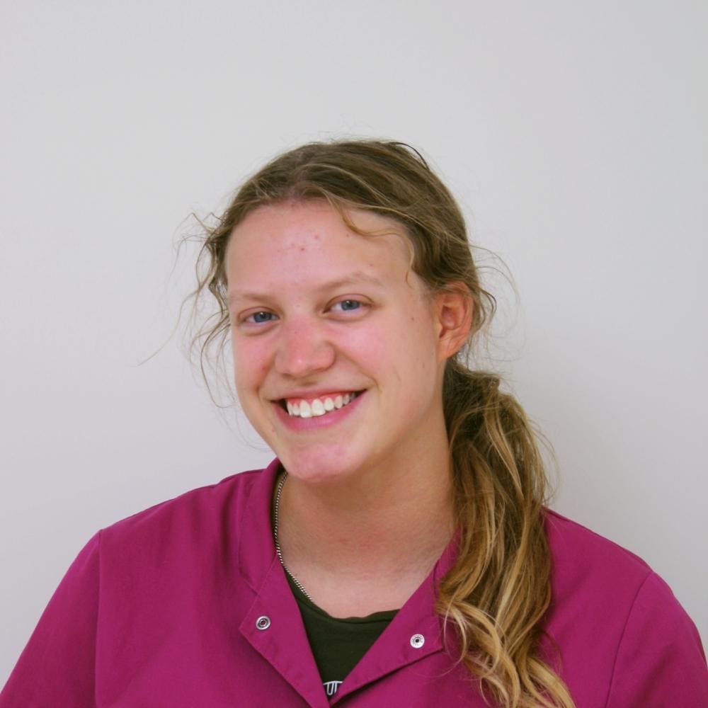 Portret van een medewerker van de kliniek in roze werkkleding